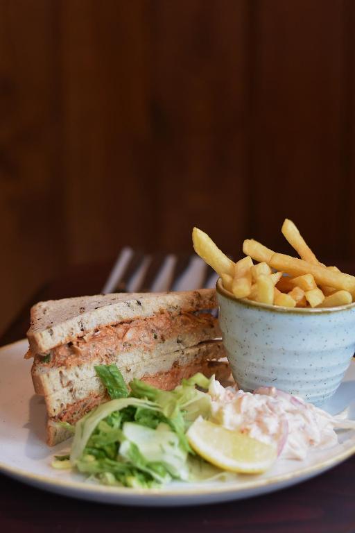 a plate of food with a sandwich and french fries at The Olde Ship Inn in Seahouses