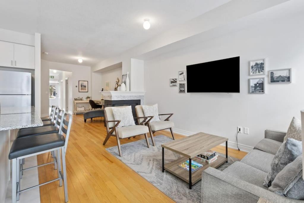 a living room with a couch and a tv on a wall at Mountain View Townhouse Fresh and Bright at Blue in Collingwood