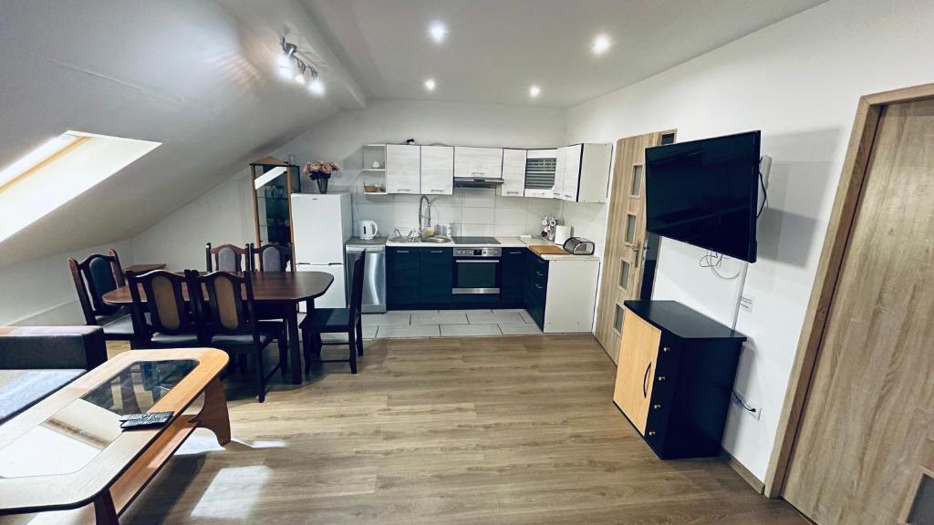 een kleine keuken en eetkamer met een tafel en stoelen bij Apartament Pod Kasztanami - BIAŁY in Ińsko