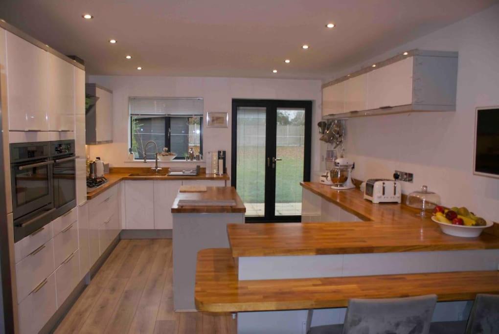 a kitchen with white cabinets and a wooden counter top at Luxury detached house - Village 