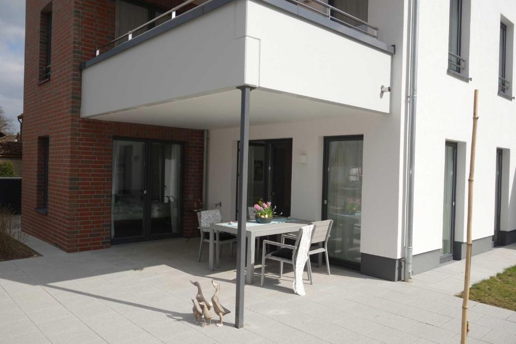 un dosel blanco en un patio con mesa y sillas en Strandgut en Häven
