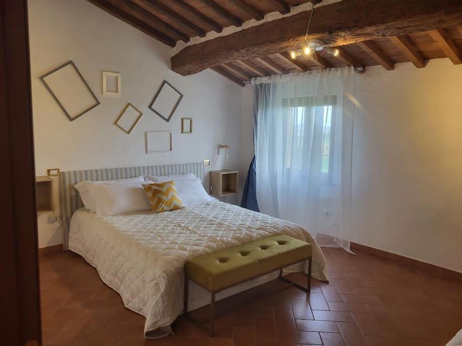a bedroom with a large bed and a window at Suite Bellavista con angolo cottura in Peccioli