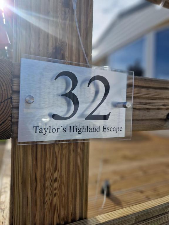 un panneau sur un poteau en bois avec le dessus dans l'établissement Taylor's Highland Escape, Dornoch, à Dornoch