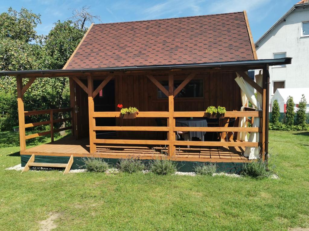 a wooden gazebo in a yard with a roof at Drewniane domki w Wilkasach in Wilkasy