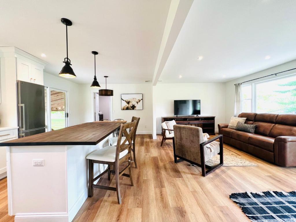 eine Küche und ein Wohnzimmer mit einem Tisch und Stühlen in der Unterkunft The Cottage at Glenwood Retreats 