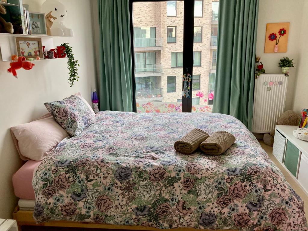 una camera da letto con un letto e due pantofole sopra di Cozy two bedroom Apartment near city centre Gent a Gand