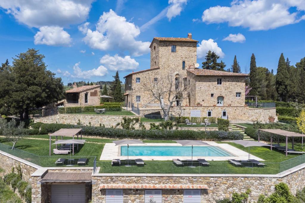 zewnętrzny widok na duży kamienny dom z basenem w obiekcie Villa Conca d'Oro by Mmega w Greve in Chianti