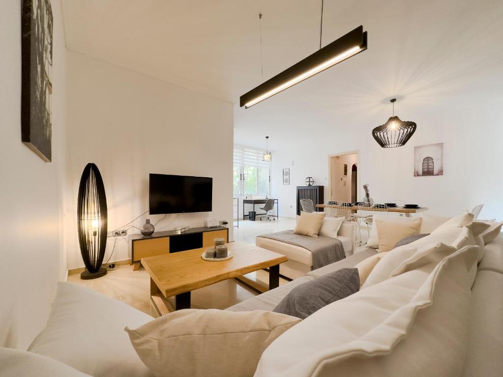 a living room with white furniture and a tv at Kairi Cozy 92sqm apt in Nea Smirni in Athens