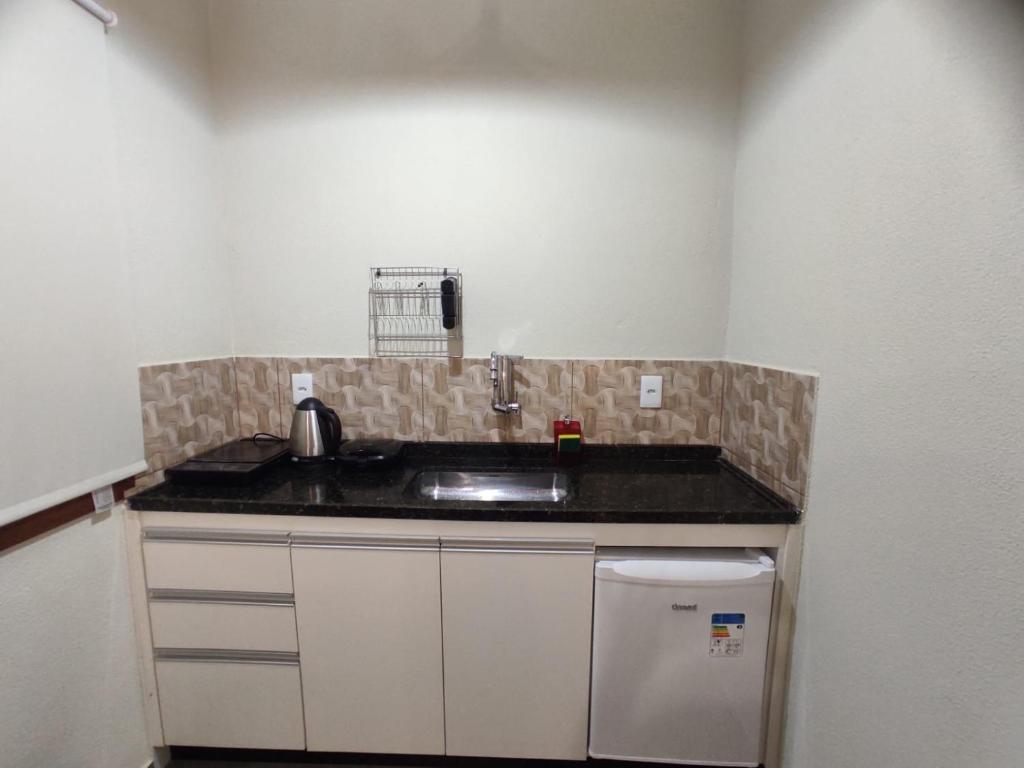 eine Küche mit einer Spüle und einer Arbeitsplatte in der Unterkunft TEMPO FLATS E HOSPEDAGEM in Alto Paraíso de Goiás