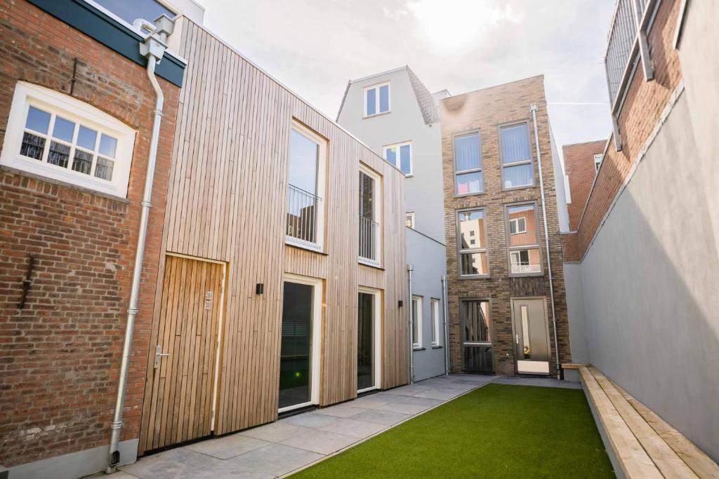 an alleyway between two buildings with a green lawn at Happy 1 Bedroom Apartment in Tiel
