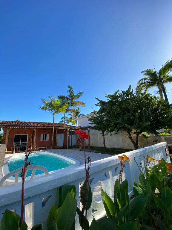 una piscina junto a una casa con palmeras en Casa em condomínio a 500m da praia de Pernambuco ideal para família, en Guarujá