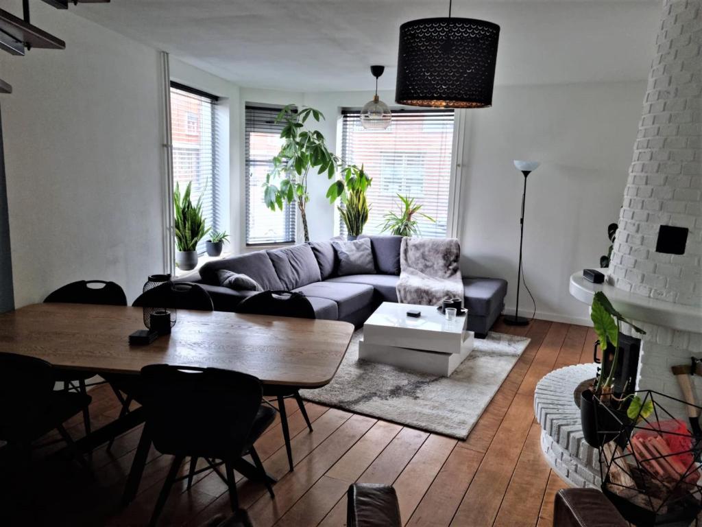 a living room with a couch and a table at Cosy & modern 3 bedroom house close to the beach in Katwijk aan Zee