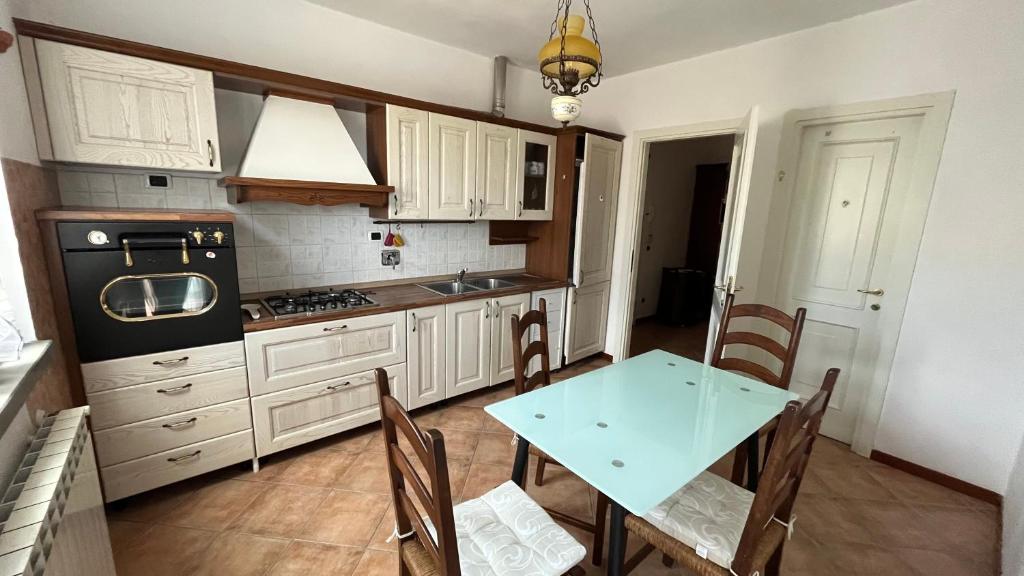 une cuisine avec des placards blancs et une table avec des chaises dans l'établissement La casa della Nonna, à Figline Valdarno