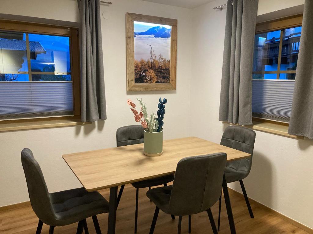 a dining room table with chairs and a vase on it at Appartement Stefanie in Hollersbach im Pinzgau