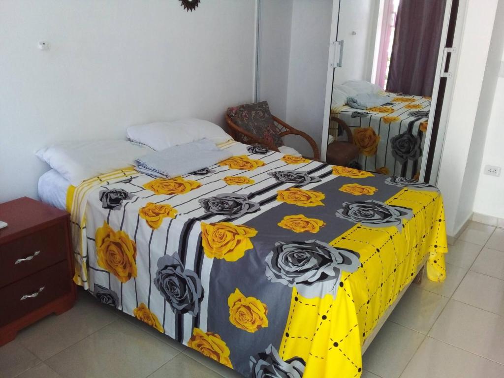 1 dormitorio con 1 cama con manta amarilla y blanca en Appart-hotel Veras Samana No 13, en Santa Bárbara de Samaná