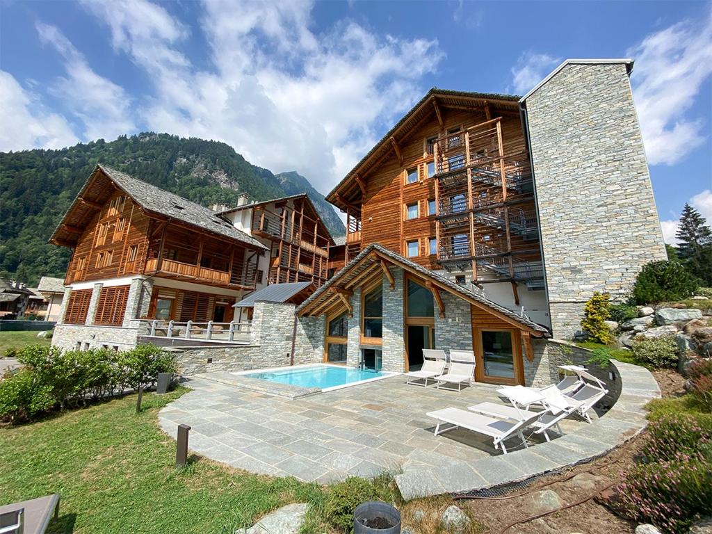 a large building with a pool in front of it at Alagna Mountain Resort & SPA in Alagna Valsesia