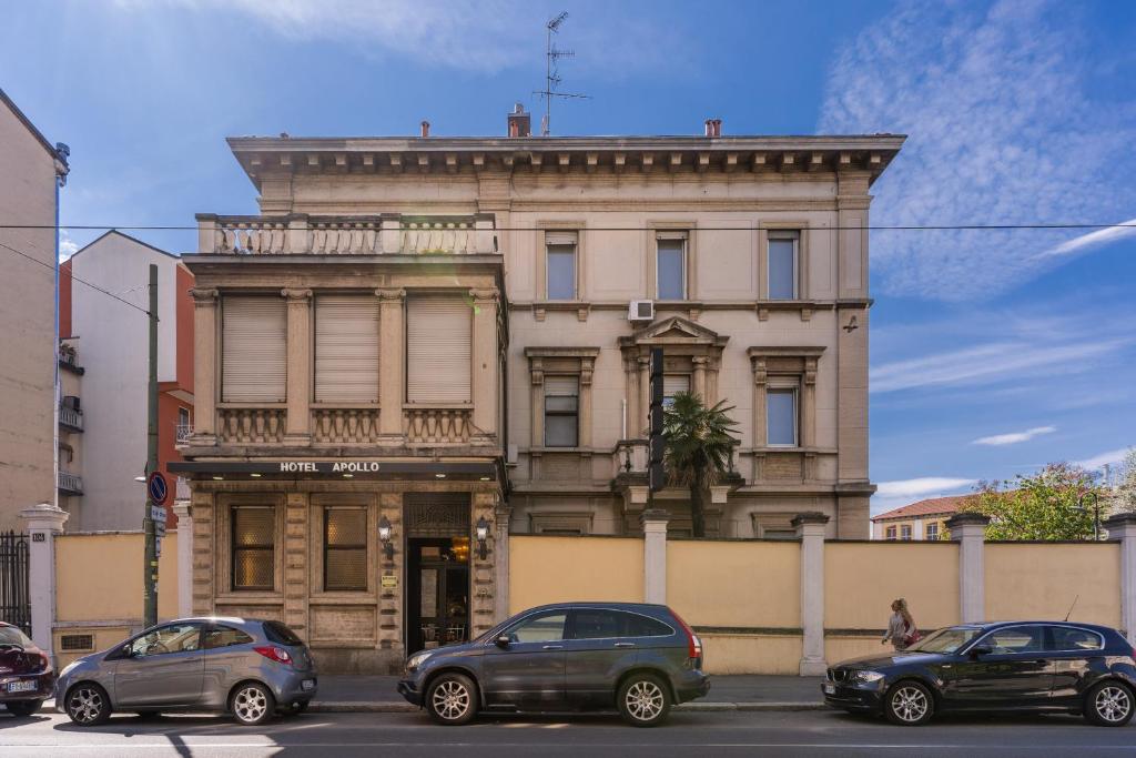 un edificio con coches estacionados frente a él en Hotel Apollo, en Milán