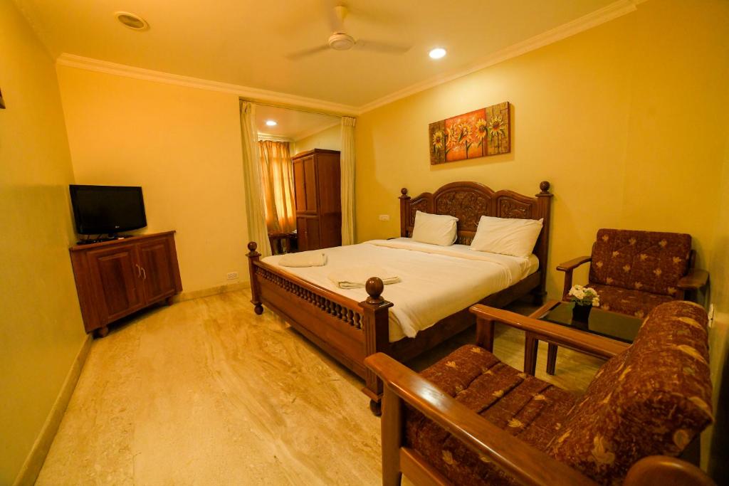 a bedroom with a bed and a tv and a couch at HOTEL UDUPI INTERNATIONAL in Nāgercoil