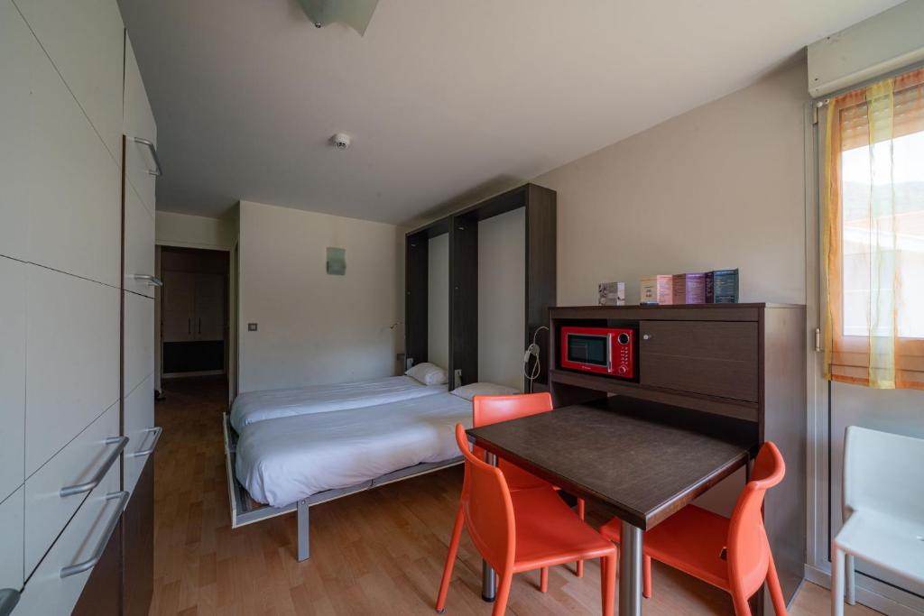 拉路謝的住宿－Residence RADIANA，一间卧室配有一张床、一张桌子和一张桌子