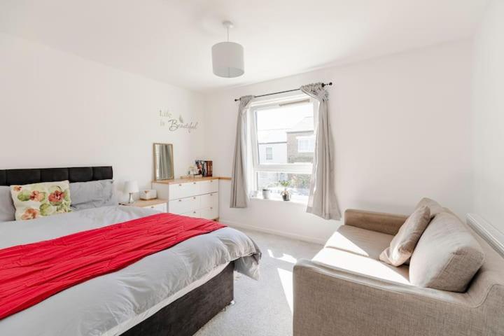 a bedroom with a bed and a couch and a window at London Home With A Beautiful View in Upper Norwood