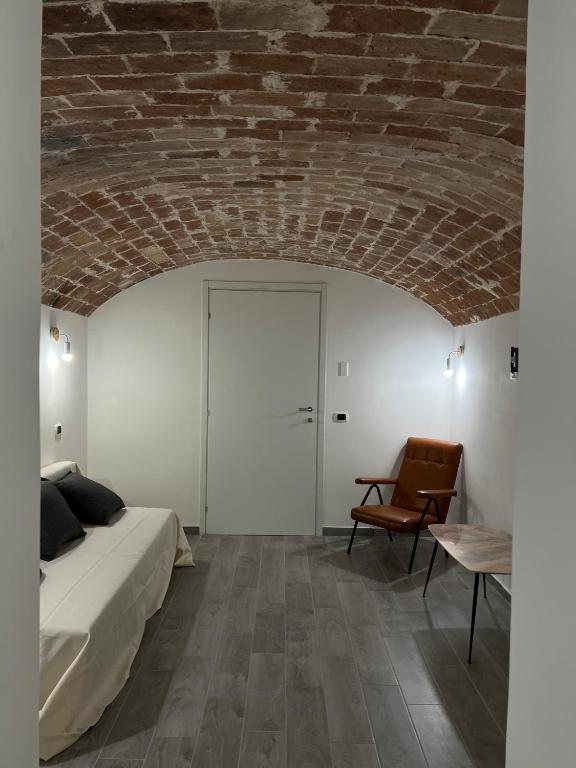 1 dormitorio con techo de ladrillo, 1 cama y 1 silla en Quartuccio a Pereto en Pereto