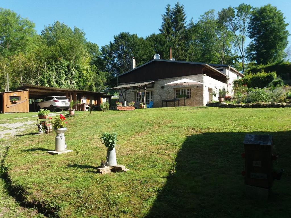 uma casa com um quintal com dois vasos com flores em Gîte l'Olivianne em Crépy-en-Valois