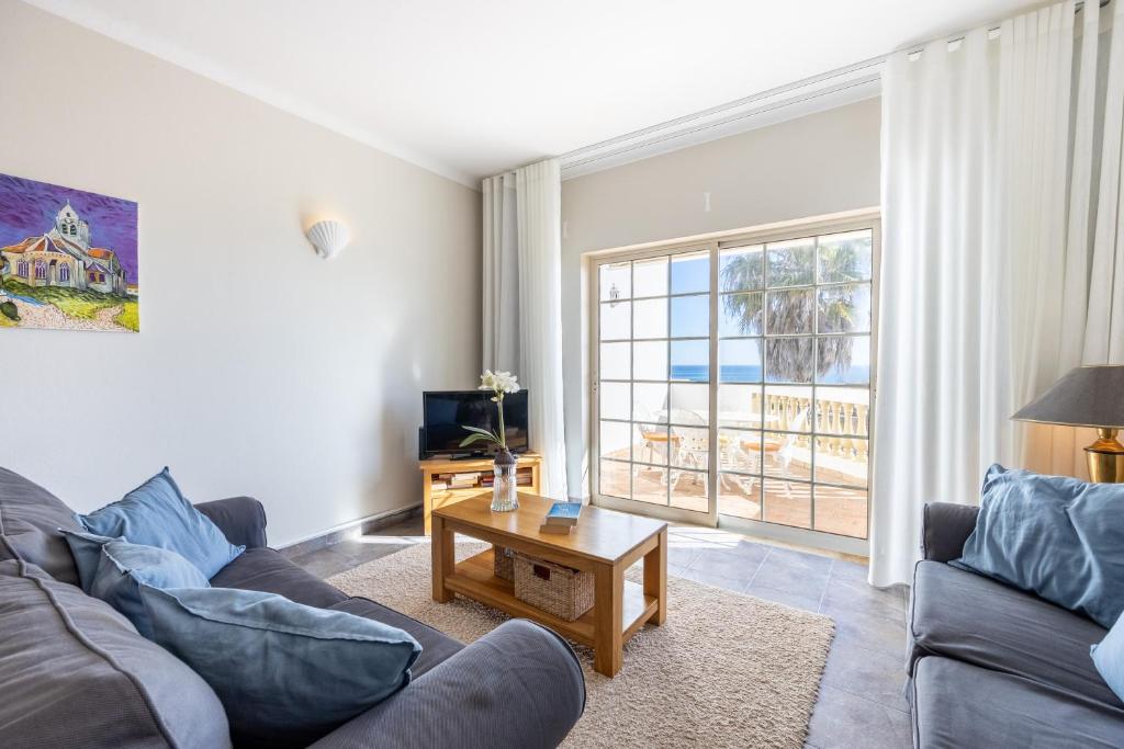 een woonkamer met een bank en een salontafel bij CoolHouses Algarve Luz, 1 bed penthouse flat w/ sea views. Fiji 11 in Luz