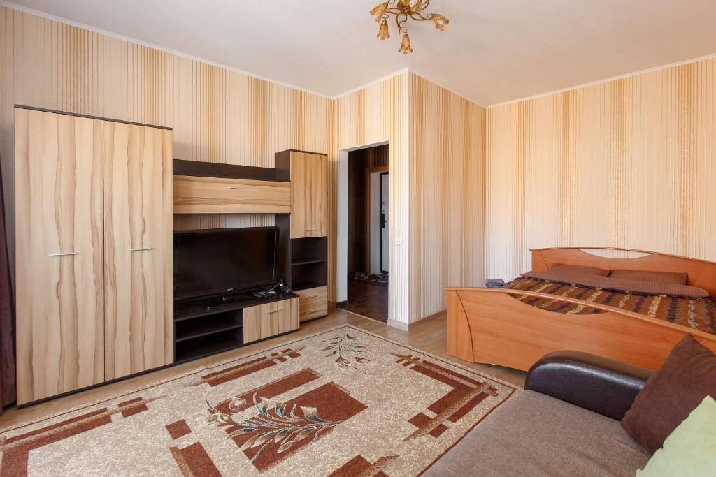 um quarto com uma cama e uma televisão de ecrã plano em 1-комн. кв. в ЖК Дуэт em Kokshetau