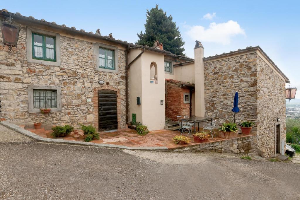 uma casa de pedra com uma mesa em frente em Poggio alla Pieve - Blu em Calenzano