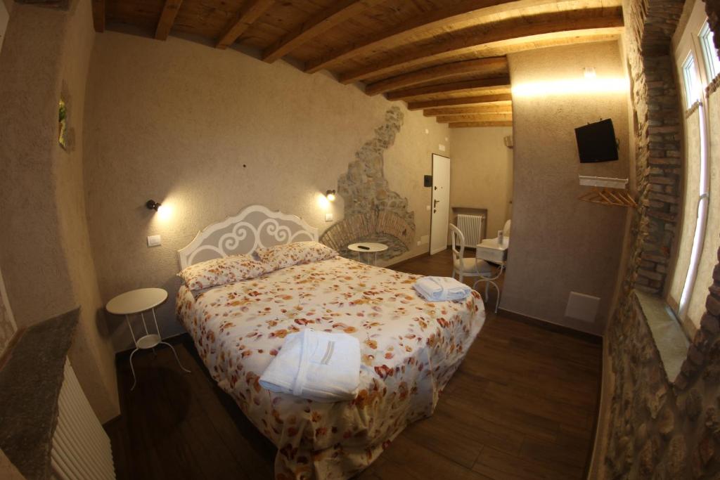 ein Schlafzimmer mit einem großen Bett in einem Zimmer in der Unterkunft Locanda Vecchia Osteria in Varese