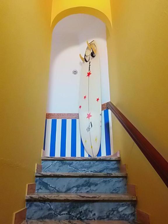 a surfboard is sitting on top of a staircase at Carrapateira Lodge in Carrapateira