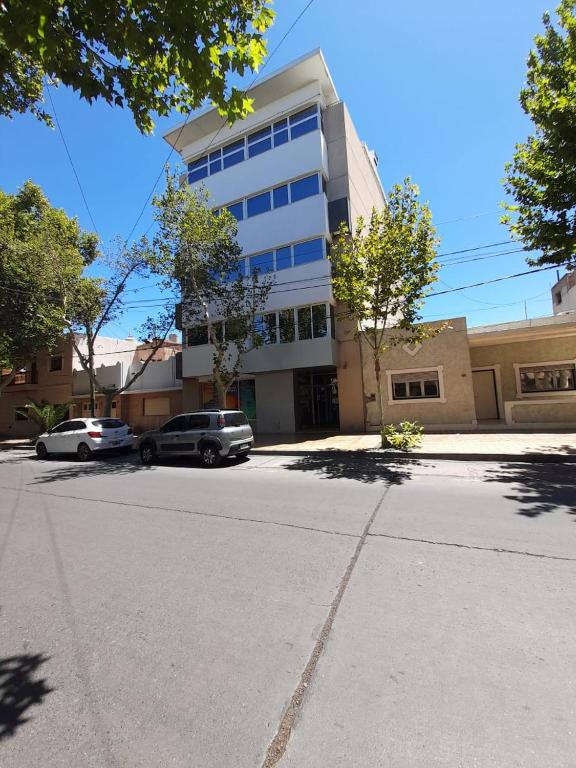 a building with cars parked in front of a street at Guemes Apartment in San Juan