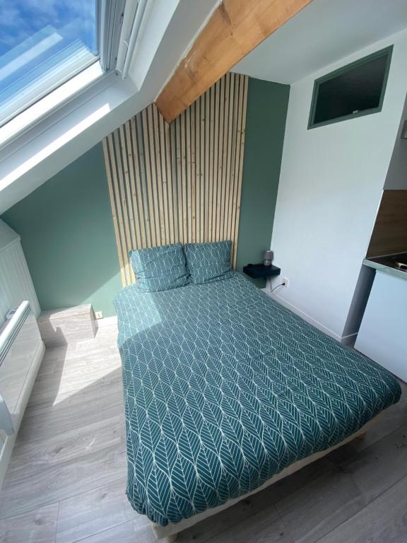 een slaapkamer met een bed met een blauw dekbed bij Une virée à Dunkerque entre ville et plage in Duinkerke
