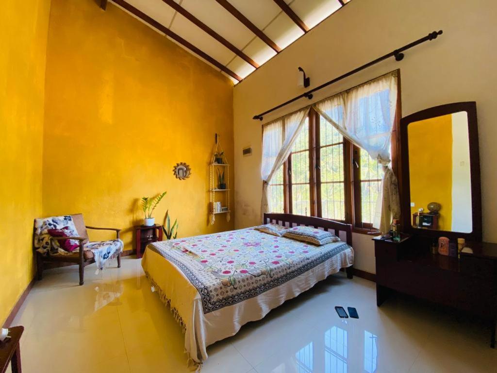 a bedroom with a bed and a large window at Pearl's Homestay Matale in Matale