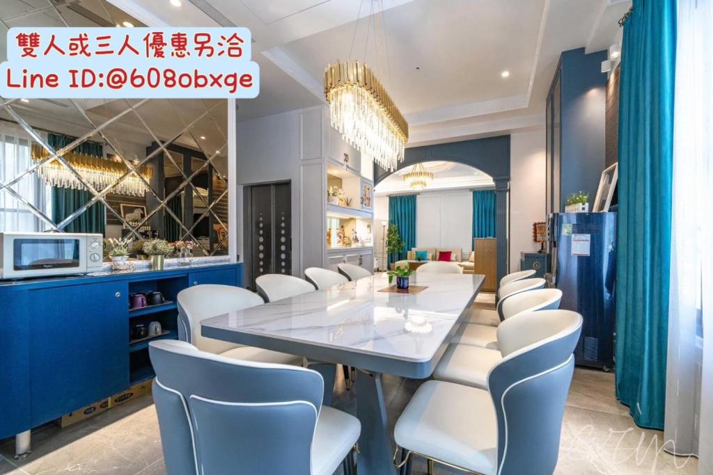 una sala da pranzo con tavolo bianco e sedie bianche di 松晏民宿 a Luodong