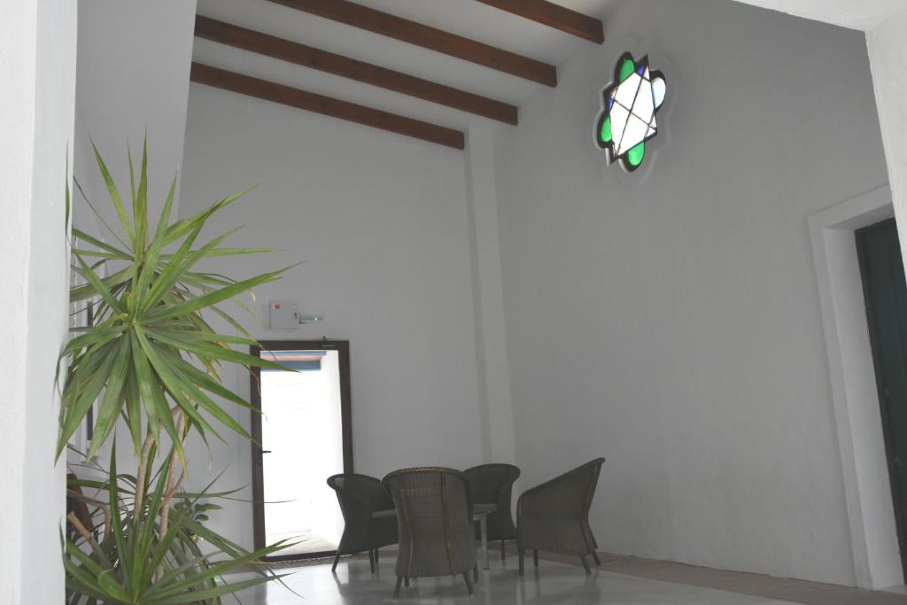 a dining room with a table and chairs and a plant at Hostal Doña Lola Marina in Zahara de los Atunes