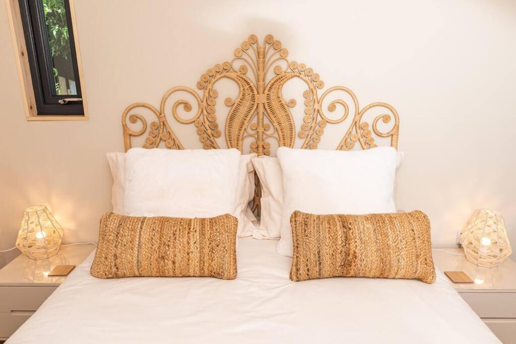 a white bed with white pillows and a gold headboard at Gingerbread Lodge in Torquay