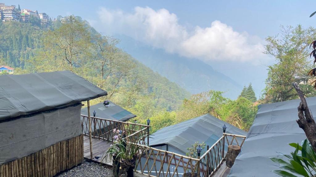 a view of a house with mountains in the background at Deoja Forest Stay in Darjeeling