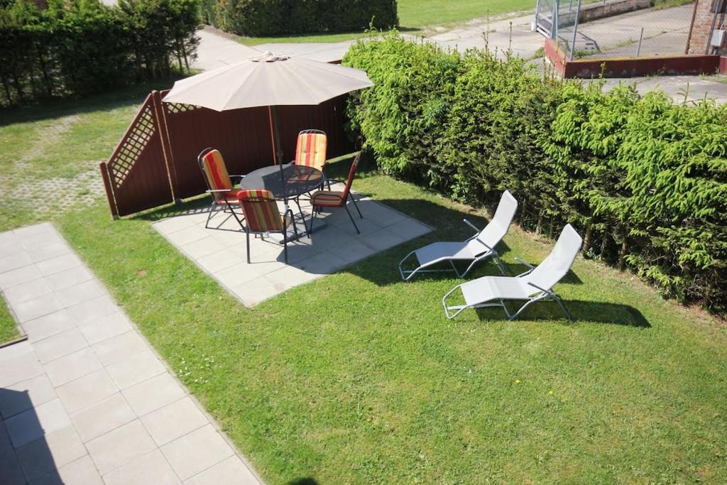 Ludorf的住宿－Müritzbrise 3，庭院配有桌椅和遮阳伞。