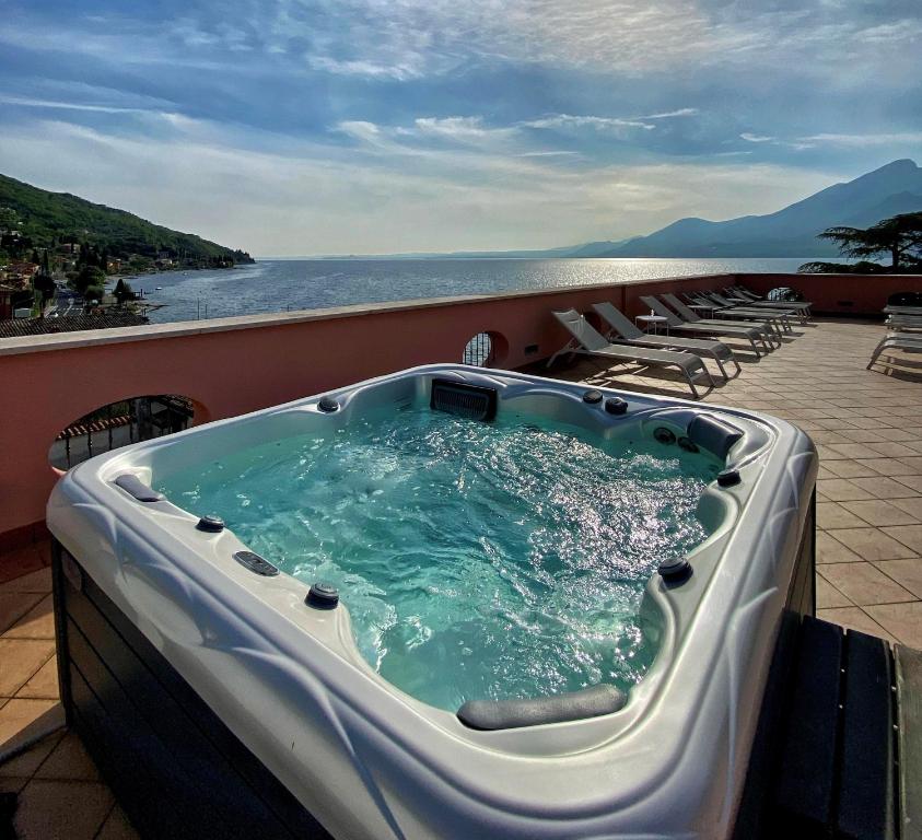 bañera de hidromasaje en el balcón de un complejo en Hotel Pai, en Torri del Benaco