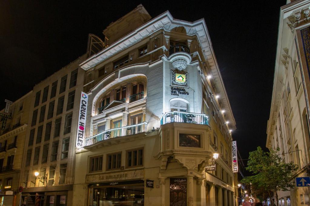 un edificio con un reloj al costado. en Casual del Teatro Madrid en Madrid