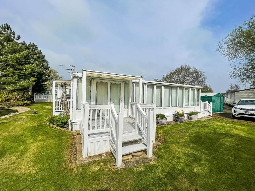 a white house with a porch and a yard at Lovely Caravan With Large Decking At Southview Holiday Park Ref 33108s in Skegness