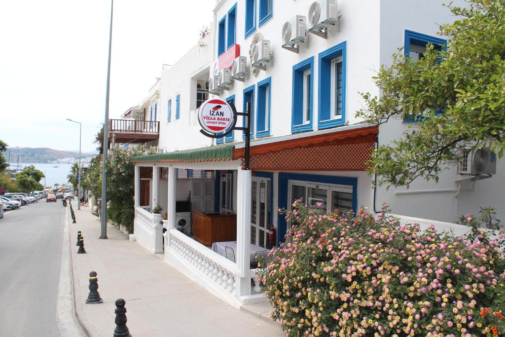 a building with blue windows on a city street at İZAN VİLLA BAKIŞ APARTMENTS in Bodrum City