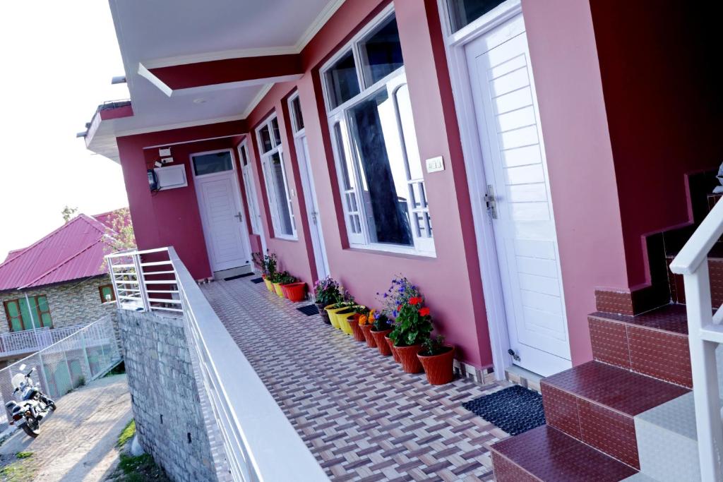 a pink house with potted plants in front of it at Himalayan Homestay in Dharamshala