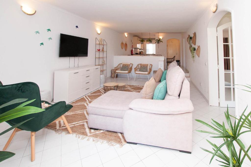 a living room with a white couch and a tv at Windmill by OCvillas in Albufeira