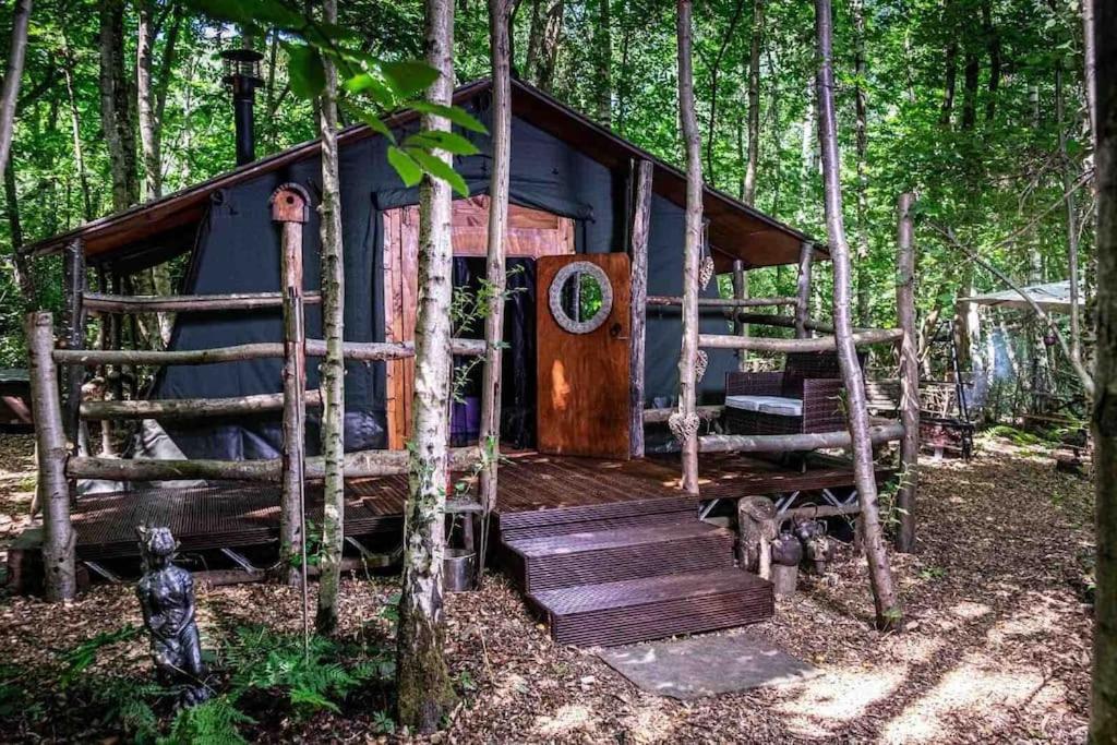 una cabaña azul en el bosque con escaleras que conducen a ella en Cosy woodland Romantic retreat With log fires and nature, en Sturry