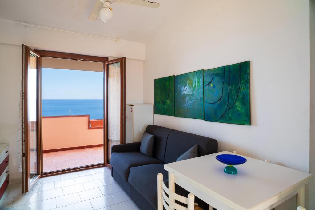 a living room with a couch and a table at Casa Vacanza Vista Mare in SantʼAlessio Siculo