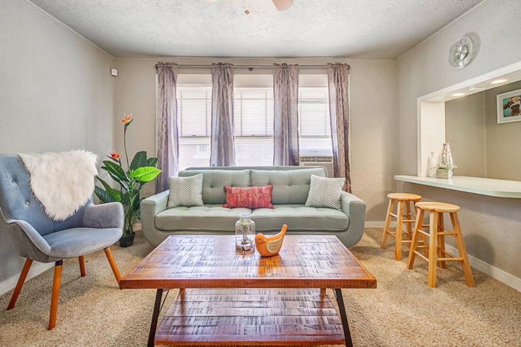 een woonkamer met een bank en een tafel bij Cozy & Comfy - Few blocks away from Plaza District in Oklahoma City