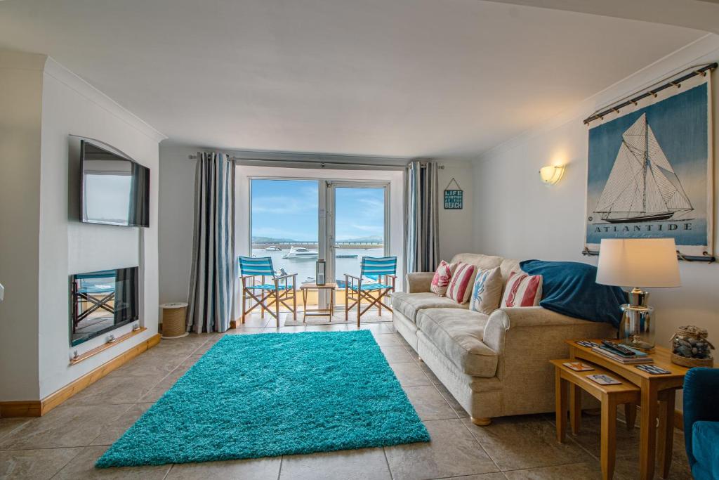 a living room with a couch and a table and chairs at Saltwhistle Beach- Couples Retreat in Teignmouth