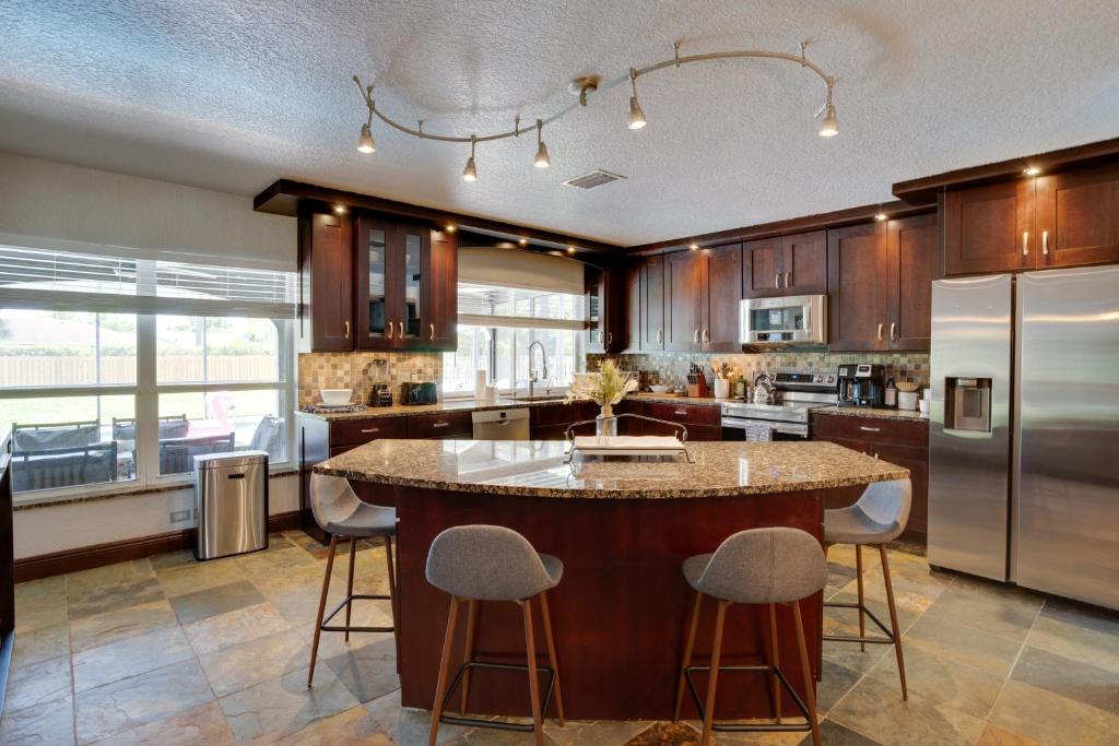 a kitchen with a large island with bar stools at Spacious Wellington Vacation Rental - Private Pool in Wellington
